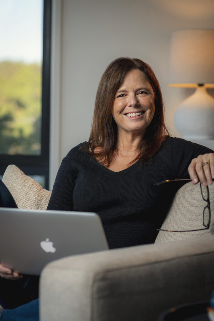 Noni Potter sitting on couch with laptop